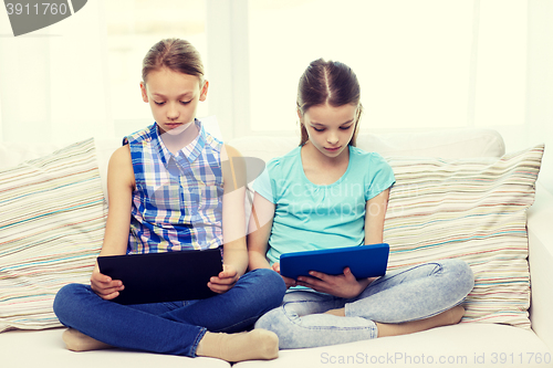 Image of girls with tablet pc sitting on sofa at home