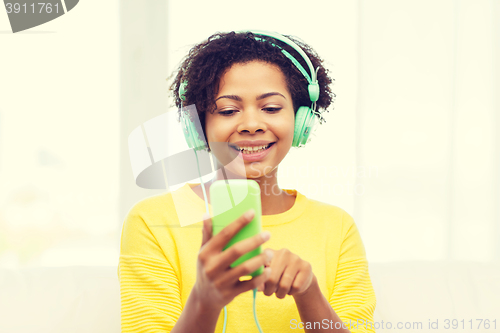 Image of happy african woman with smartphone and headphones