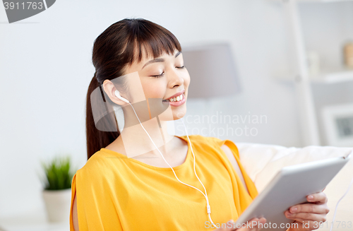 Image of happy asian woman with tablet pc and earphones