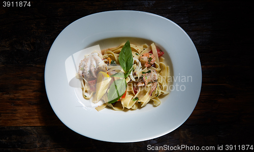 Image of Fettuccine pasta  with shrimps, lemon, baby octopus, fresh Parmesan cheese, and  oregano. 