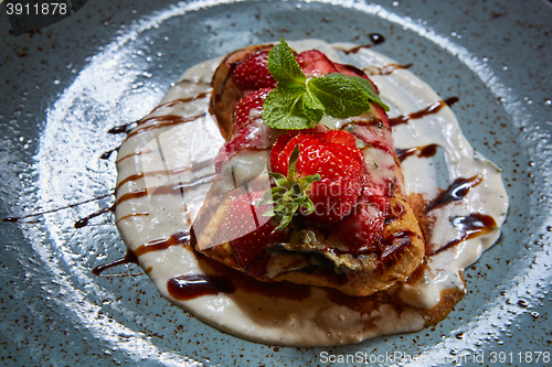 Image of Whole wheat Belgium waffle topped with syrup, whipped cream, walnuts and freshly chopped strawberries 