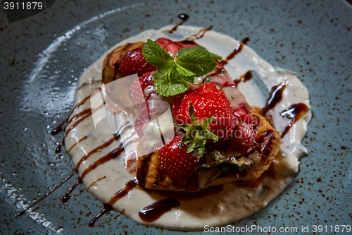 Image of Whole wheat Belgium waffle topped with syrup, whipped cream, walnuts and freshly chopped strawberries 