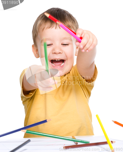 Image of Little boy is playing with color pencils