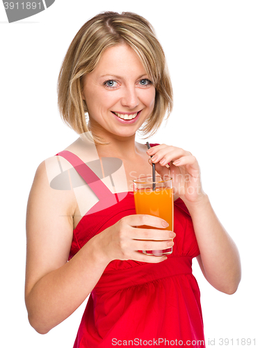 Image of Young woman is drinking carrot juice