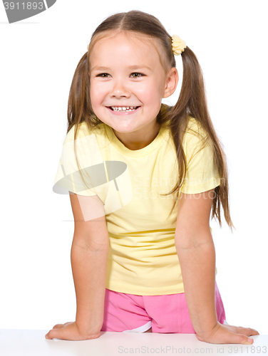 Image of Portrait of happy little girl leaning on a table