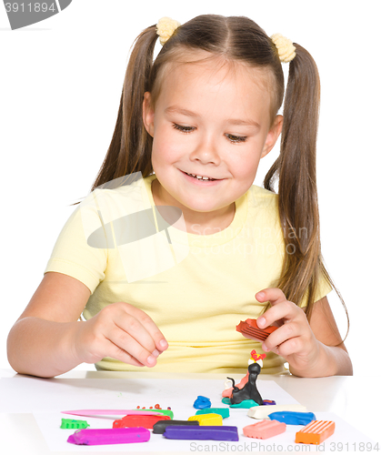 Image of Little girl is playing with plasticine