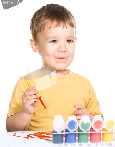 Image of Little boy is playing with paints