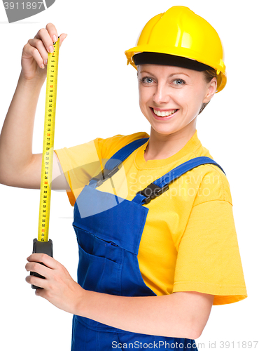 Image of Young construction worker with tape measure