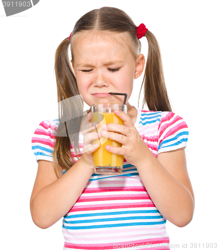 Image of Little girl unwillingly drinking orange juice