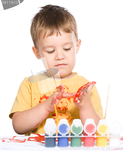 Image of Little boy is playing with paints