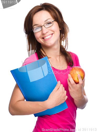 Image of Young student girl is holding book and apple