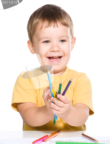 Image of Little boy is playing with color pencils