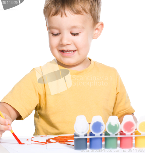 Image of Little boy is playing with paints