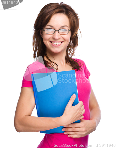 Image of Young skinny student girl is holding exercise book