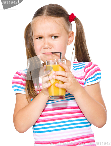 Image of Little girl unwillingly drinking orange juice