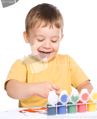 Image of Little boy is playing with paints