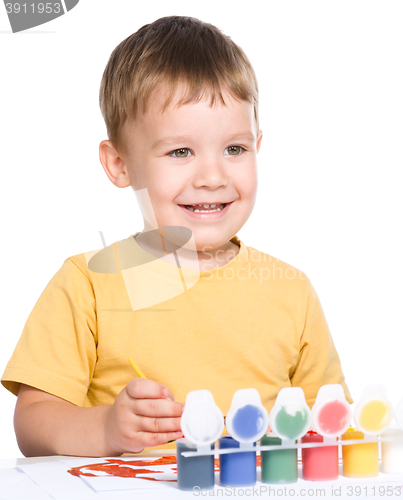 Image of Little boy is playing with paints