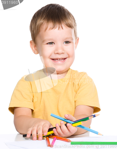 Image of Little boy is holding color pencils