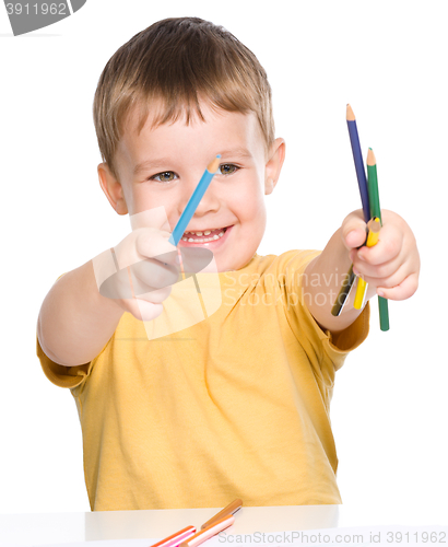 Image of Little boy is playing with color pencils