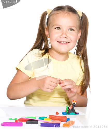 Image of Little girl is playing with plasticine