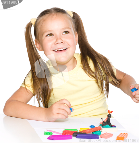 Image of Little girl is playing with plasticine