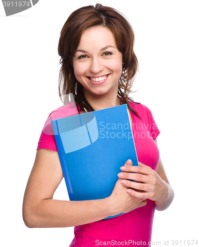 Image of Young student girl is holding exercise book