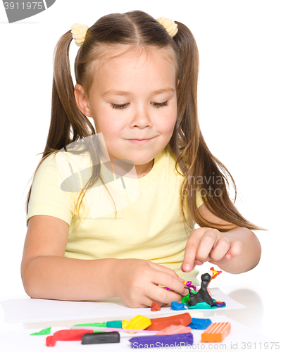 Image of Little girl is playing with plasticine