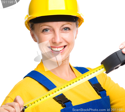 Image of Young construction worker with tape measure