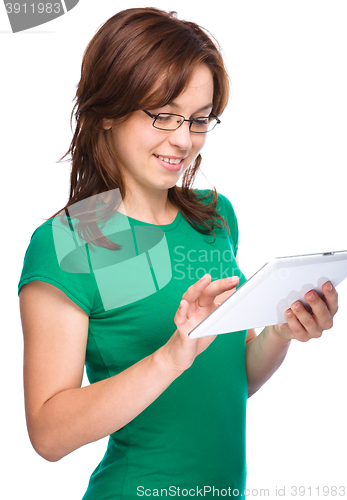 Image of Young cheerful woman is using tablet