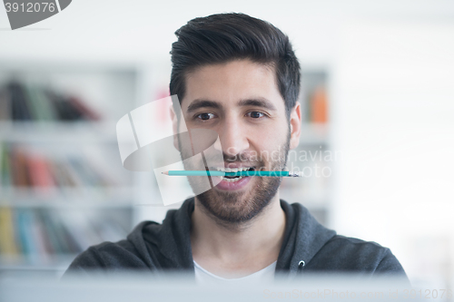 Image of student in school library using laptop for research