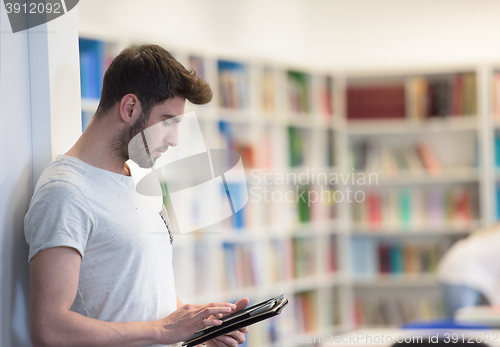 Image of student in school library using tablet for research