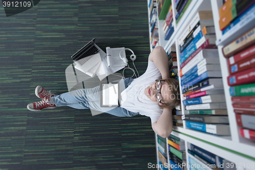 Image of female student study in library, using tablet and searching for 