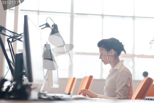 Image of business woman working on computer at office