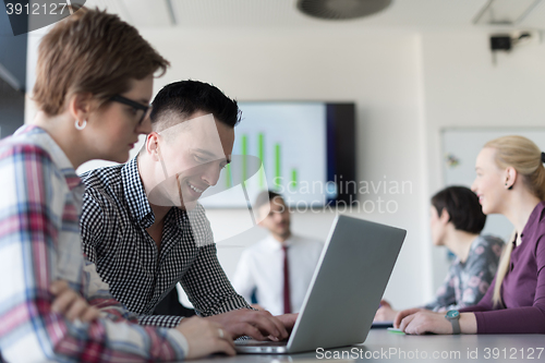 Image of young business couple working on laptop, businesspeople group on