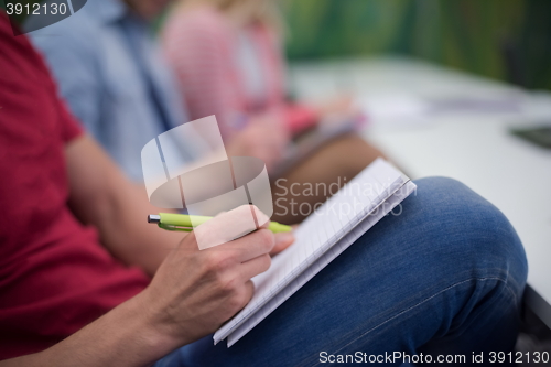 Image of male student taking notes in classroom