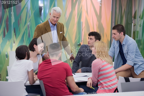 Image of teacher with a group of students in classroom