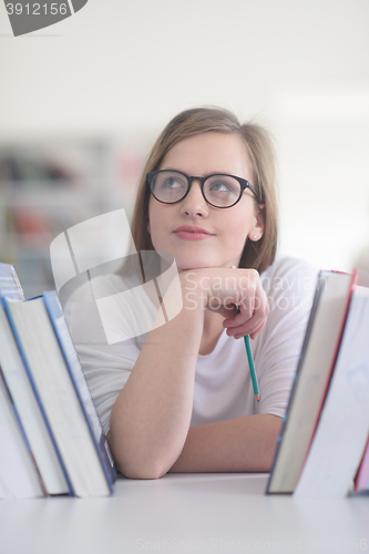 Image of portrait of famale student selecting book to read in library