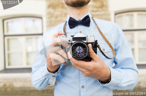 Image of close up of hipster man with film camera in city