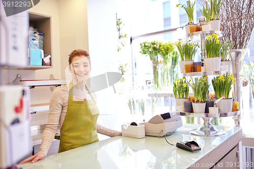 Image of happy smiling florist woman at flower shop counter