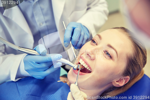 Image of close up of dentist treating female patient teeth