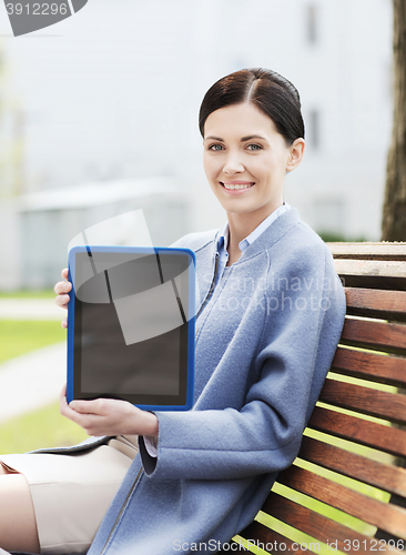 Image of smiling business woman with tablet pc in city