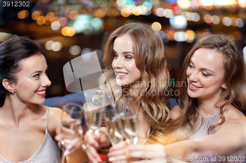 Image of happy women with champagne glasses at night club