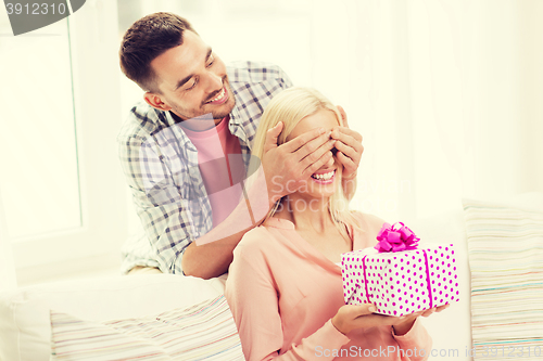 Image of happy man giving woman gift box at home