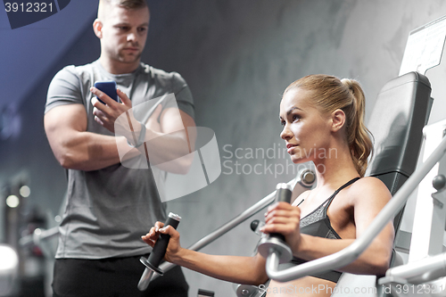 Image of man and woman flexing muscles on gym machine