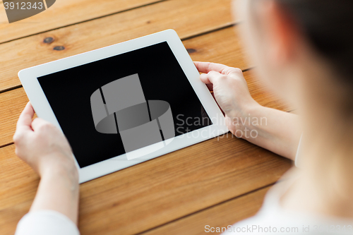 Image of close up of woman with tablet pc on wooden table