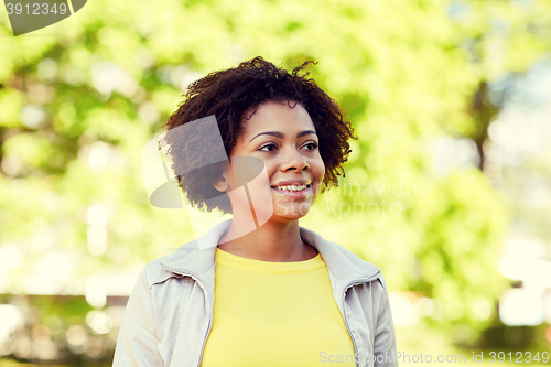 Image of happy african american young woman in summer park