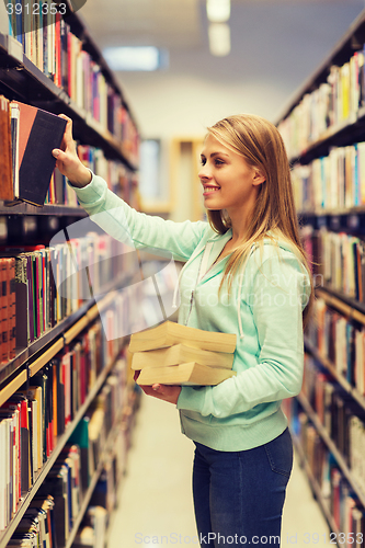 Image of happy student girl or woman with book in library