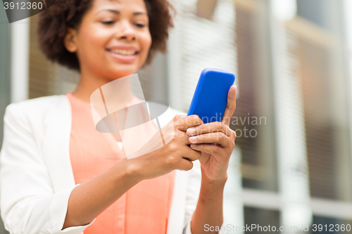 Image of close up of african woman with smartphone in city