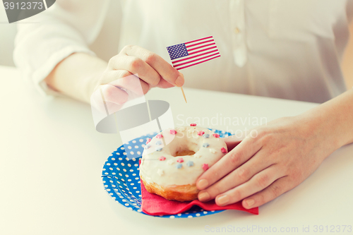 Image of female hands decorating donut with american flag