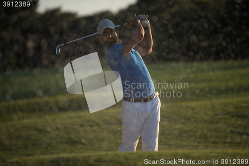 Image of golfer hitting a sand bunker shot on sunset